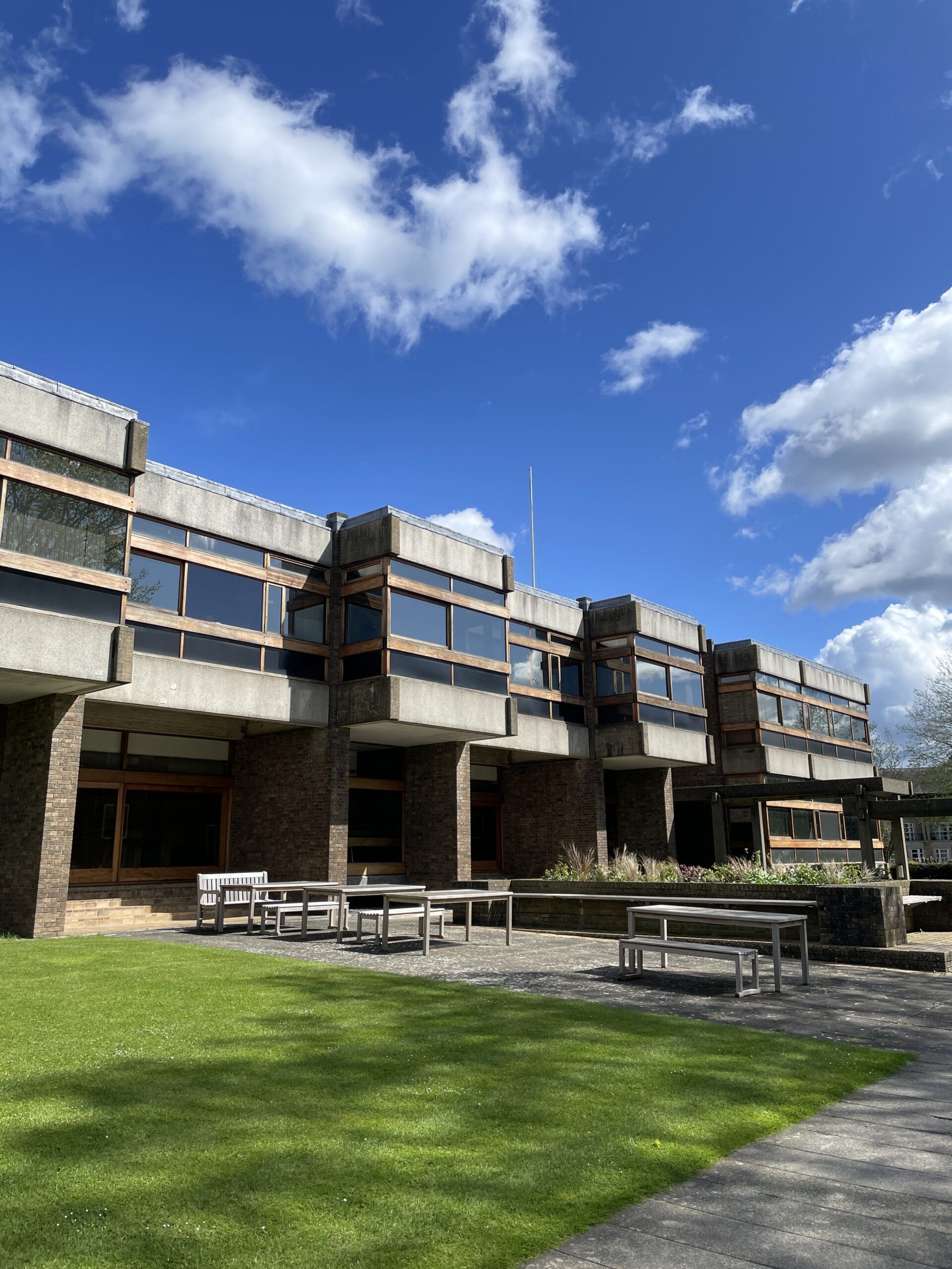 Exterior of college showing picnic tables and grass