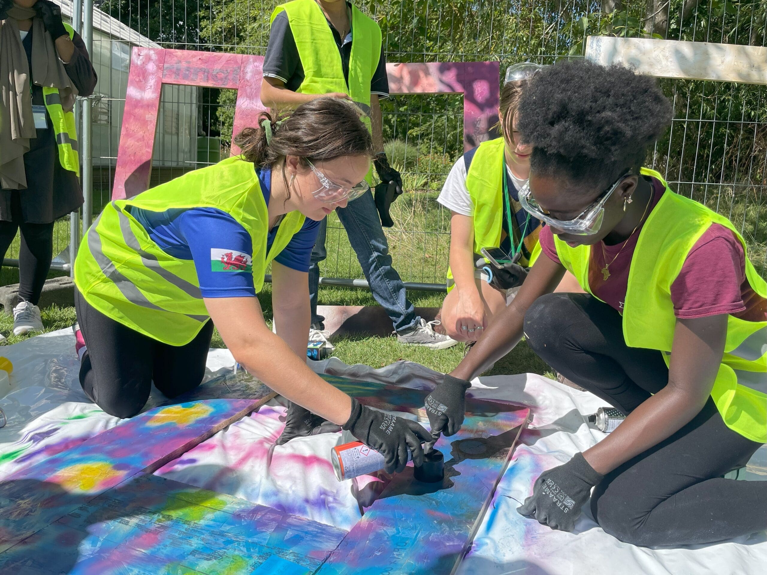 Two students work on a project wearing safety gear