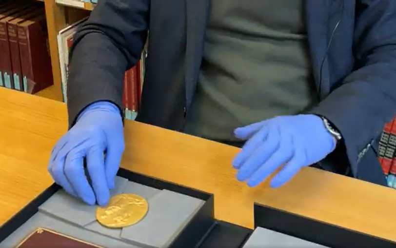 A researcher handling a nobel prize in the archives centre